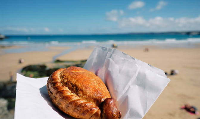 A Cornish pasty with the beach in the background