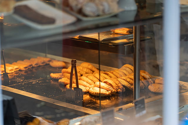 A row of Cornish pasties keeping warm in a shop window