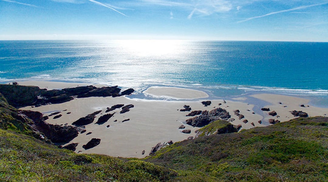 a beautiful clifftop view of a beach and sea