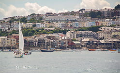 Sailing boats in the harbour, overlooked by the colourful town of Falmouth in Cornwall
