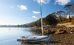 A sailing boat moored on the shore of Feock and the River Fal