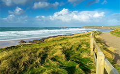 Grassy dunes and crashing waves at Gwithian in Cornwall
