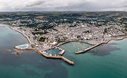 An aerial view over the town of Penzance with its harbour, and outdoor pool visible