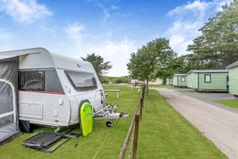 Tents on grass field at Holywell Bay
