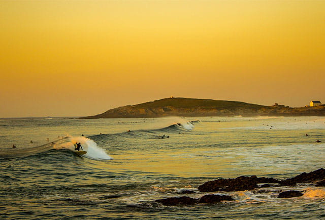 Surfers at sunset in Newquay