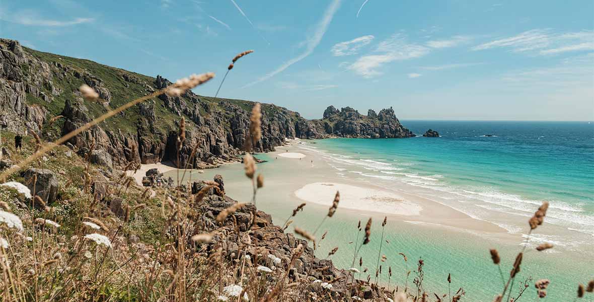 Turquoise blue waters and white sands of a beach in Cornwall