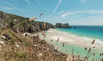 Blue waters and white sand on a sunny day in Cornwall