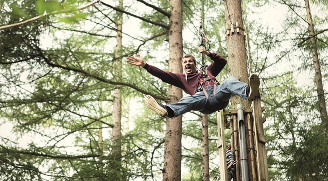 man on high rope in a forset