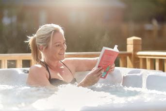 A woman reading a book in a hot tub on a Parkdean Resorts break