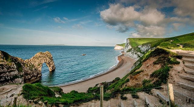 A wide angle view of Durdle Door and beach capturing the sweeping Dorset coastline