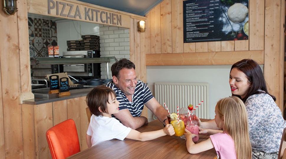 family enjoying some soft drinks at the pizza kitchen