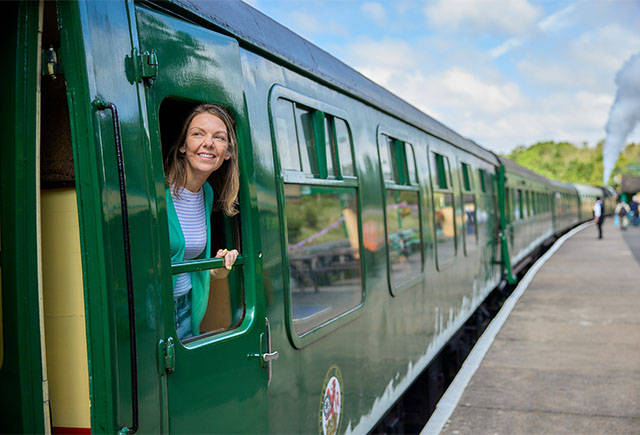 A woman looking out the window of a train on historic Swanage Railway in Dorset