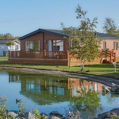 Wooden lodge sitting alongside lake