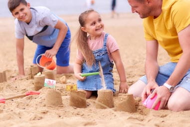 Family building sandcastles on the beach