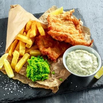 Fish, chips and peas on a slate