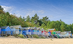 A row of colourful beach huts on the sand near Holkham in Norfolk
