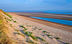 Grassy dunes lining Brancaster Beach in Norfolk