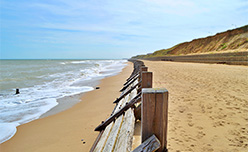 Waves lapping the golden sand of Bacton Beach in Norfolk