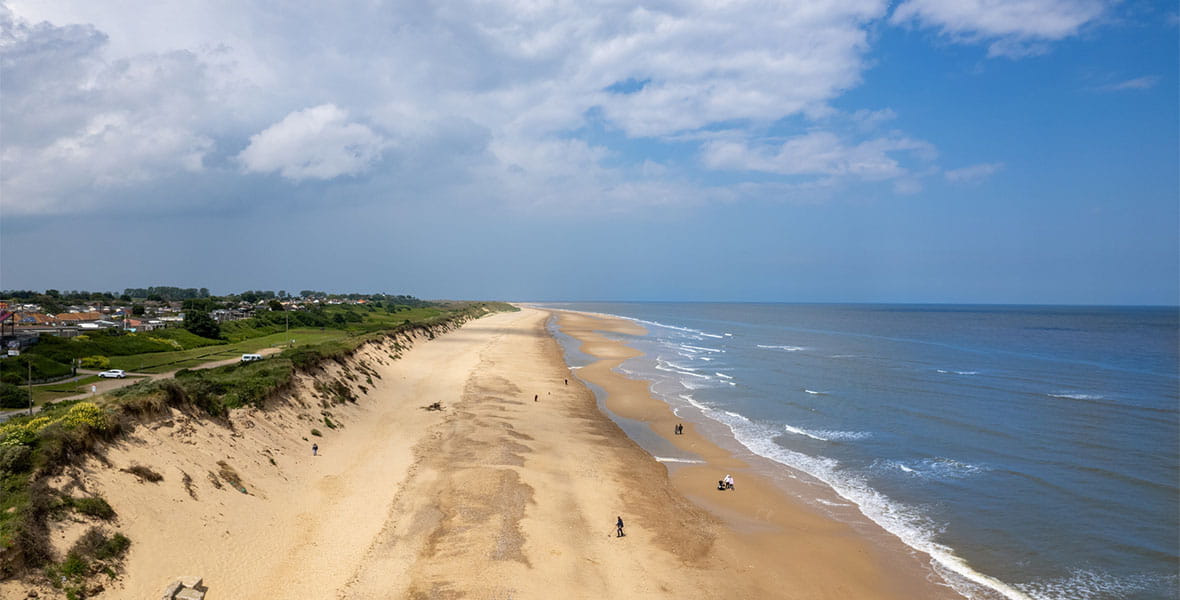 An aerial view over a beach in Norfolk on a sunny day
