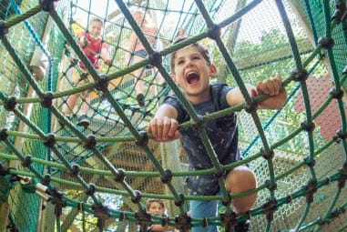 Kid laughing climbing a net