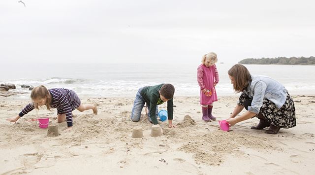 A family building sandcastles at the beach