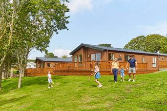 A family walking past a row of holiday lodges on the Isle of Wight