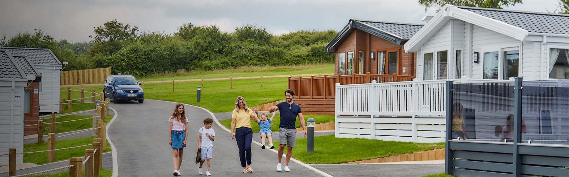 A family walking through a holiday park on the Isle of Wight with luxury lodge accommodation