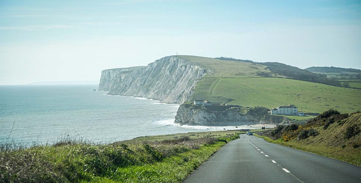 A coastal road on the Isle of Wight with the famous white cliffs visibile in the distance