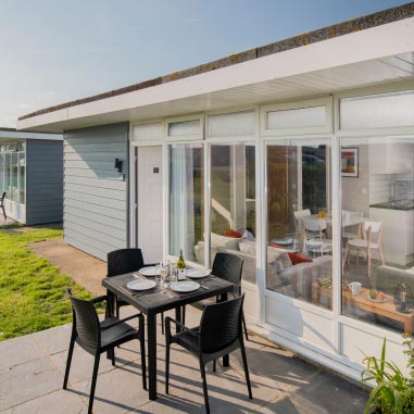 Chalet with table and chairs outside bifolding doors