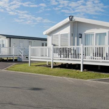 White lodge with veranda at Parkdean Resorts