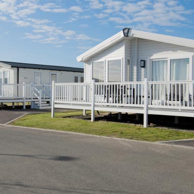 White lodge with veranda at Parkdean Resorts