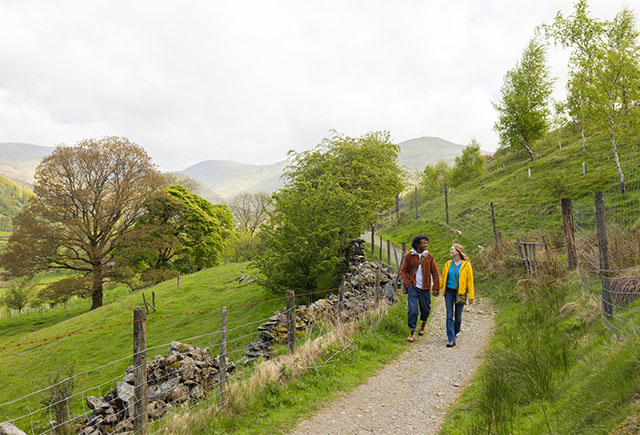 A couple walking a trail in the Lake District in spring