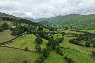 An aerial view of the fields and mountains in the Troutbeck Valley in the Lake District