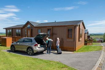 A couple unloading their car ready to check into their luxury lodge holiday in Lancashire