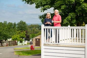 A couple of owners enjoying the veranda of their lodge holiday home