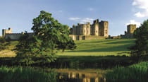 The view of Alnwick Castle in summer, looking across the river and grounds