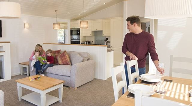 A family relaxing in their open plan lodge living area