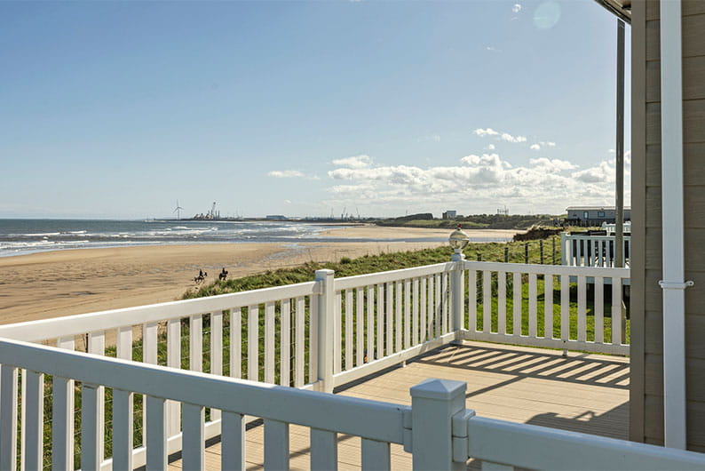 A lodge veranda overlooking the beach at Sandy Bay in Northumberland