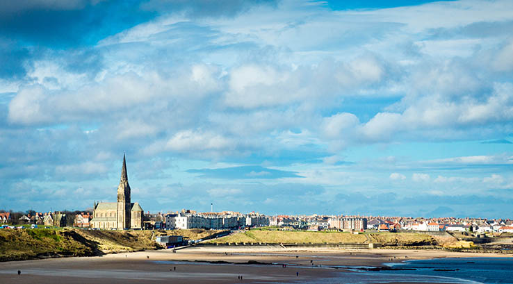 A distant view of Tynemouth beach and town