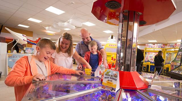 A family playing a classic arcade game