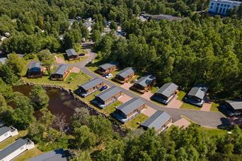 An aerial view over a woodland lodge holiday park in Scotland
