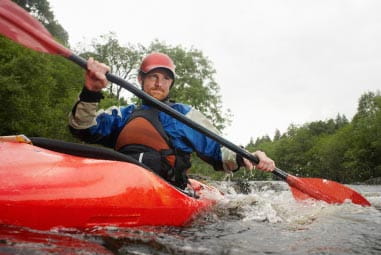Man kayaking in red kayak