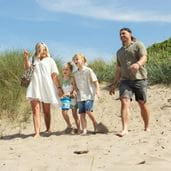 Family walking along the beach in the sun