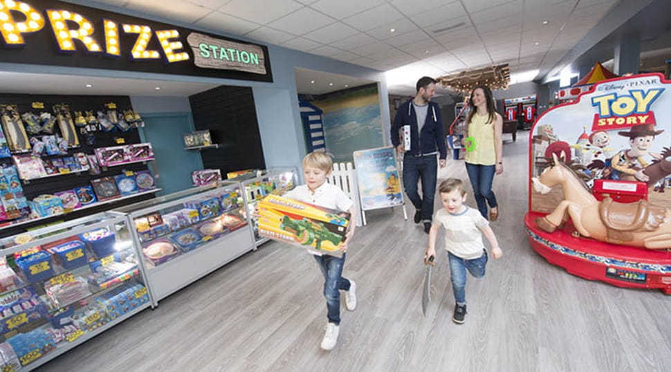 A family walking through an amusement arcade at a Parkdean Resorts Holiday Park