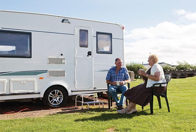 A couple sat outside a motorhome