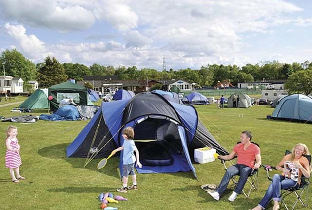 A family relaxing outside the tent at Sundrum Castle Campsite