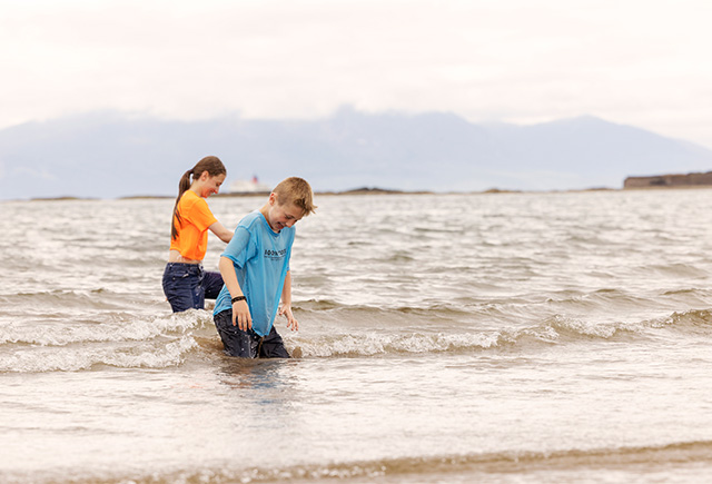 Two kids playing in the sea in Scotland