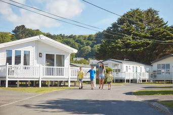 A family walking past holiday lodges in a Welsh holiday park resorts