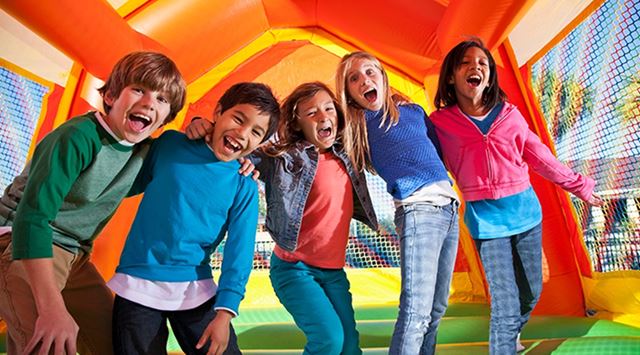 Kids laughing on an inflatable bouncy castle