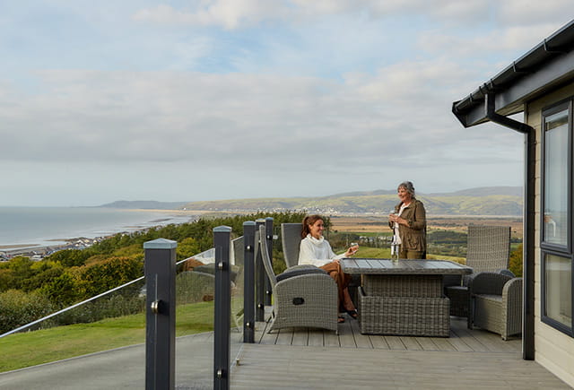 A family enjoying the views from their lodge veranda in Wales